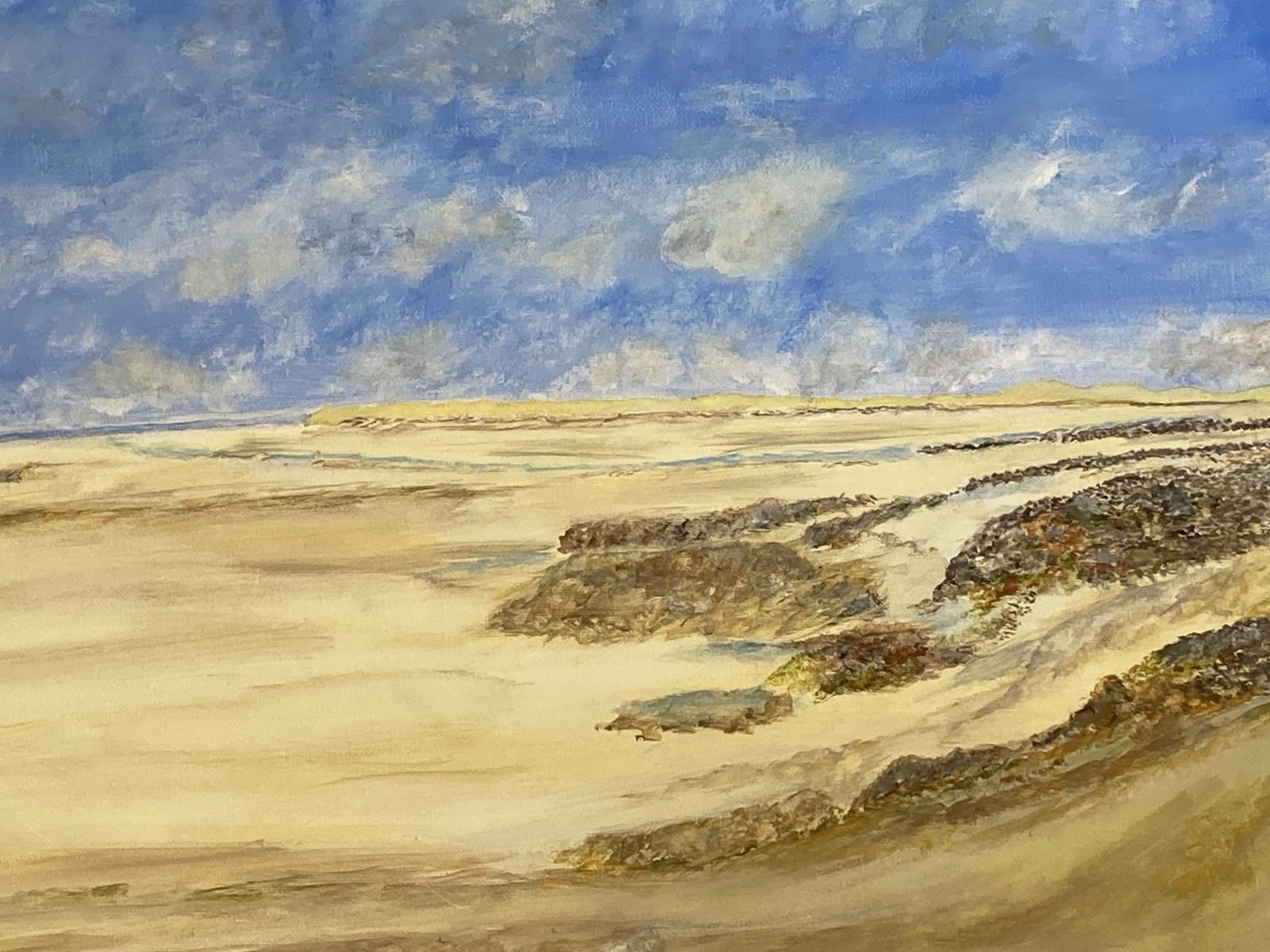 Seascape painting by Marlene Gardner: a wide sandy beach with rocks under a blue, cloud-swept sky